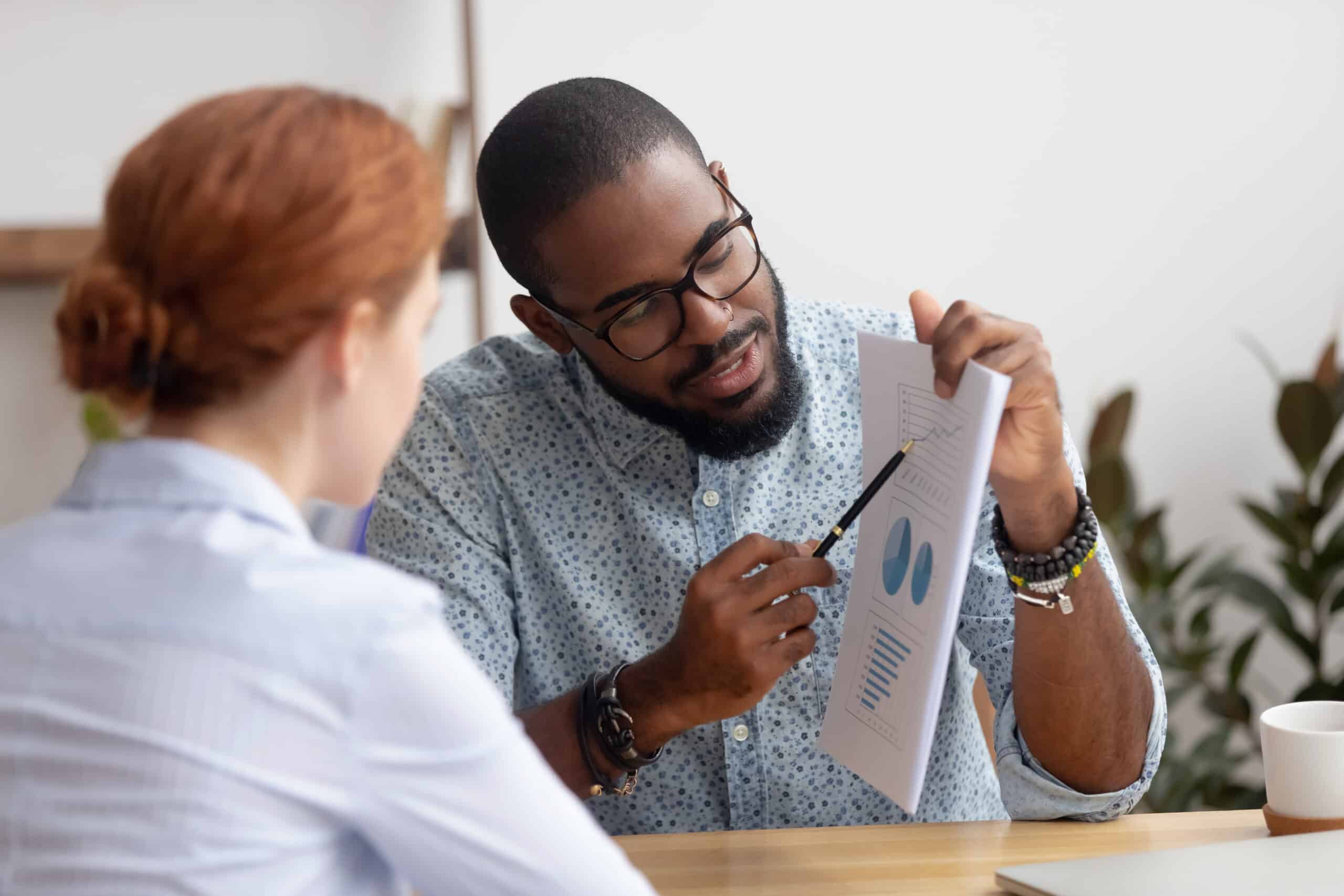 Man Presenting Charts and Graphs to Woman