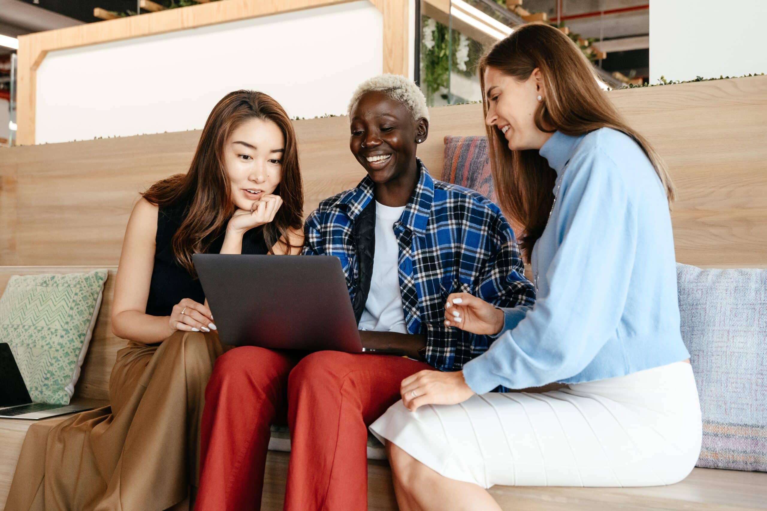 three people surround laptop