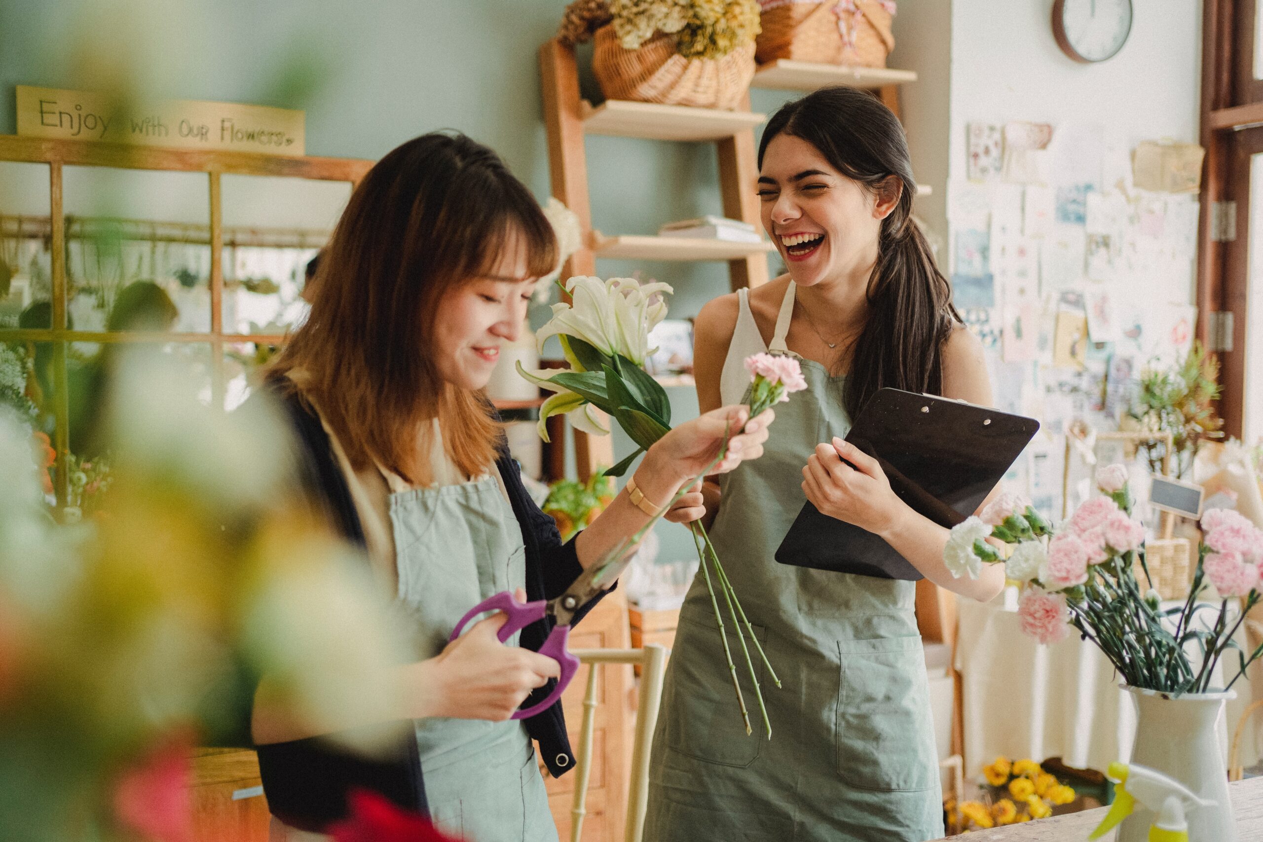 two women in floral shop smiling