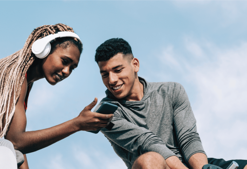 Two People Looking at Phone Outside