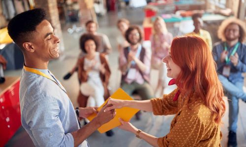 Young male employee receiving a certificate for successful training