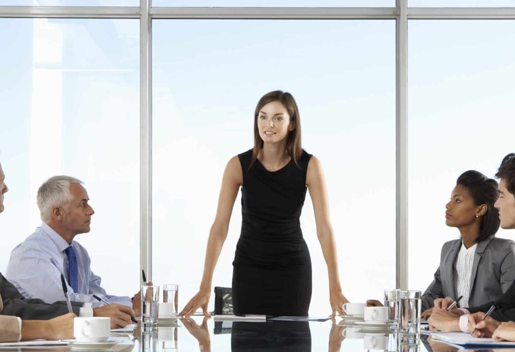 Group Of Business People Having Board Meeting Around Glass Table.